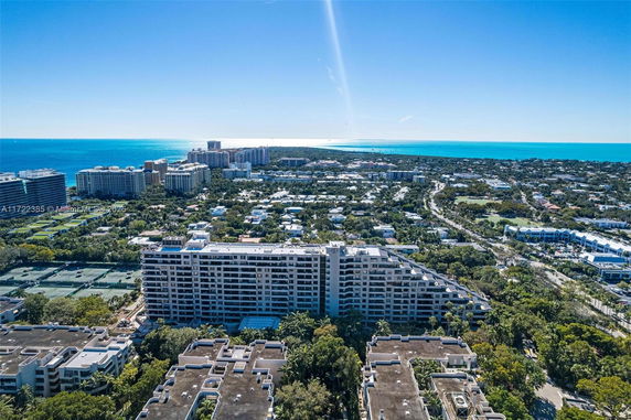 Wide angle view of an urban area with multiple buildings and a coastline in the distance.