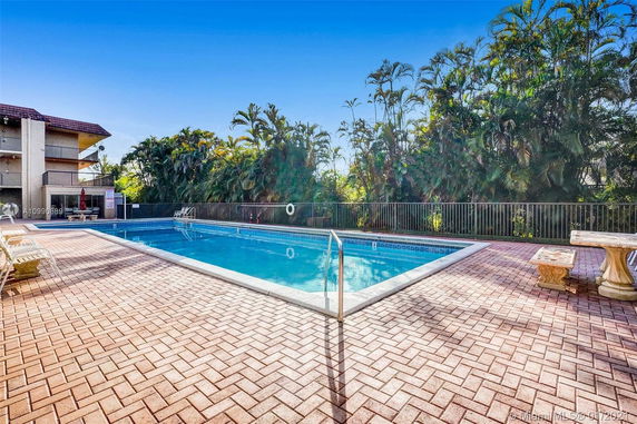 Outdoor swimming pool with surrounding deck and greenery.