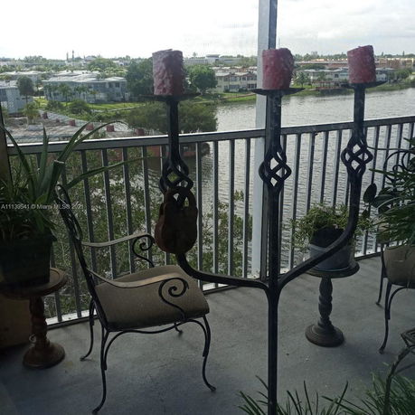 View from a balcony overlooking a lake and residential buildings.