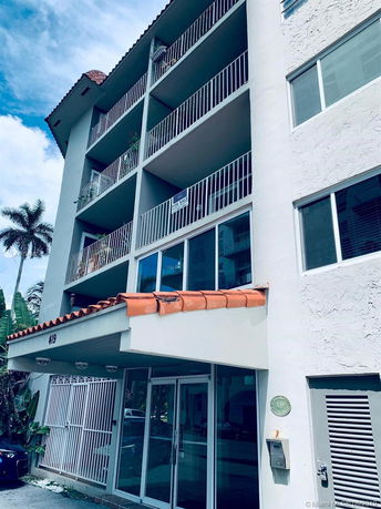 Front view of a multi-story residential building with balconies.
