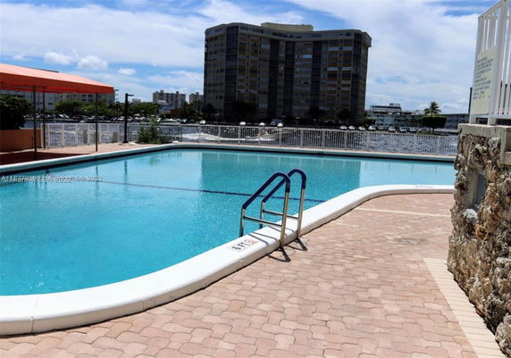 View of a swimming pool with a building in the background.