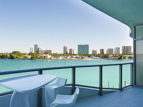 Panoramic view from a balcony overlooking a body of water and city skyline.