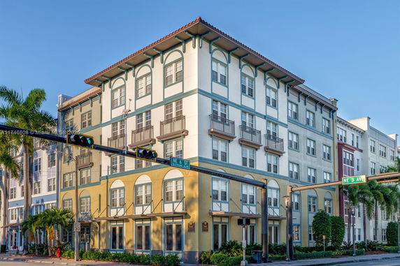 Front view of a multi-story building with large windows and decorative balconies.