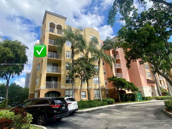 Front view of a multi-story residential building with balconies and arch details.