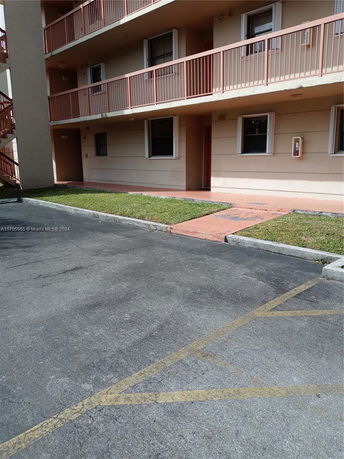 View of an apartment building with adjacent parking area