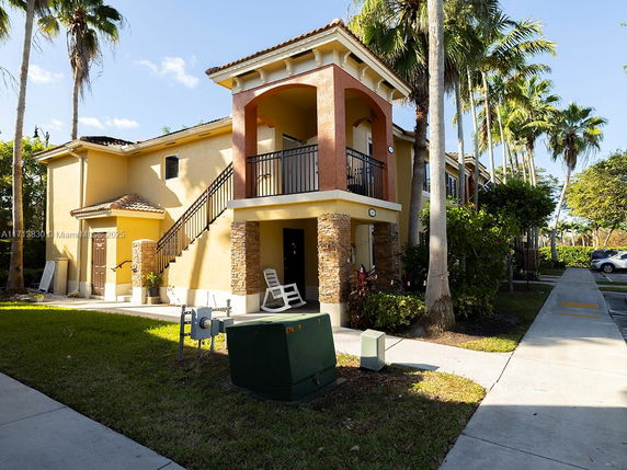 Front view of a two-story house with an outdoor staircase and balcony.