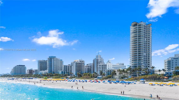 Beachfront view with several high-rise buildings in the background.