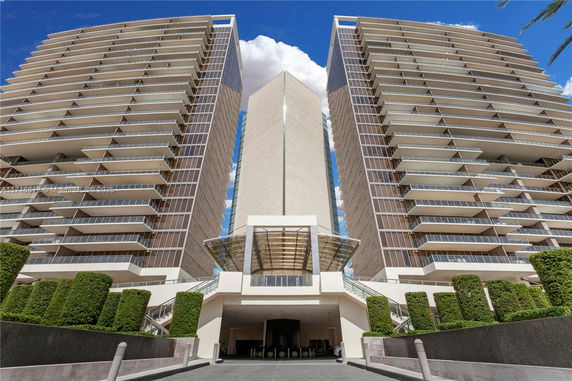 Front view of a modern high-rise building with multiple balconies.