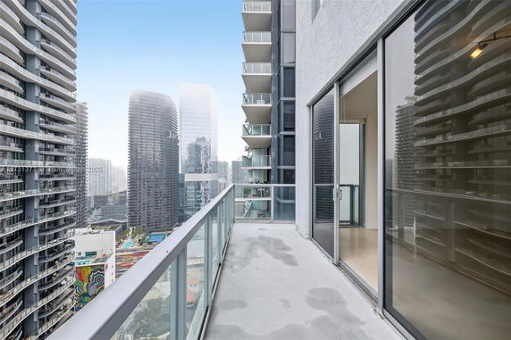 View from a balcony overlooking modern high-rise buildings.