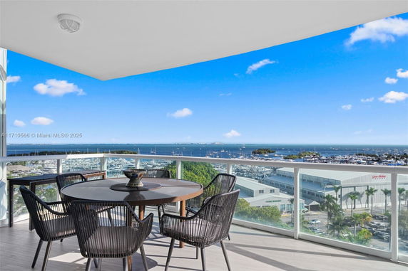 Panoramic view from a high balcony showing a marina and ocean.