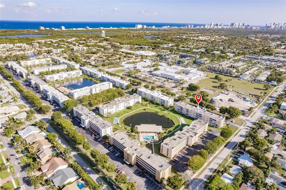 Aerial view of a residential area with multiple apartment buildings, streets, and nearby coastline.