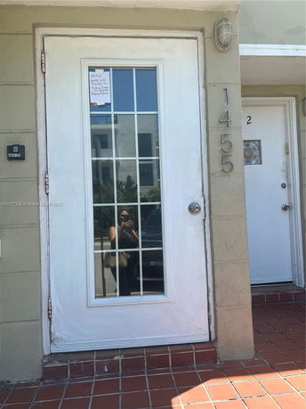 Front view of a building entrance with a glass-paneled door and house number 1455.