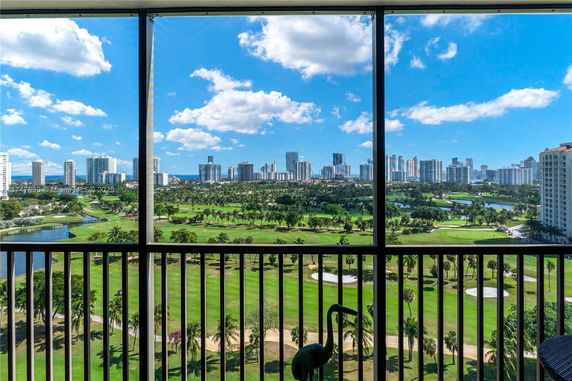 Panoramic view from a balcony overlooking a golf course and cityscape.