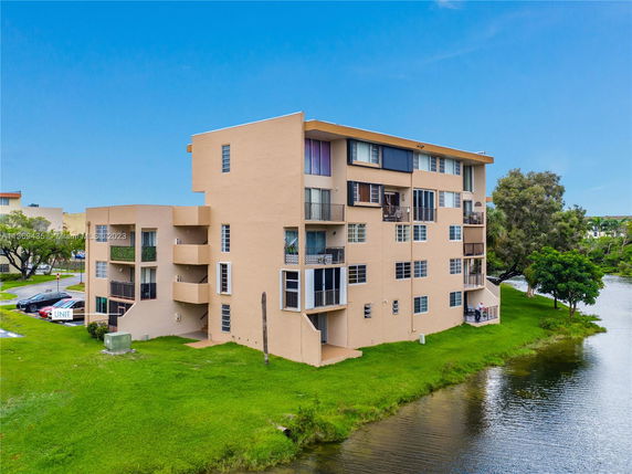 Front view of a multi-story apartment building near a water body.