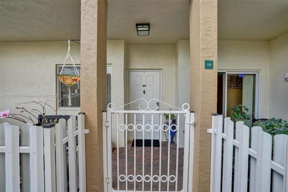 Front view of a house entrance with a white door and railing.