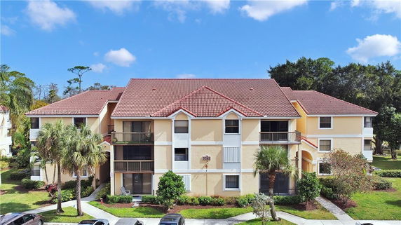 Front view of a multi-story residential building with red tile roof.
