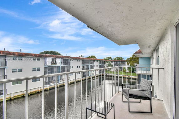 View from a balcony overlooking a waterway and adjacent apartment buildings.