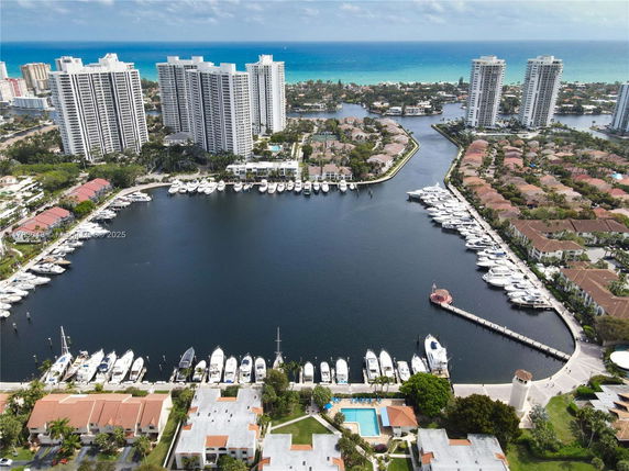 Panoramic view of tall buildings and a marina with boats.