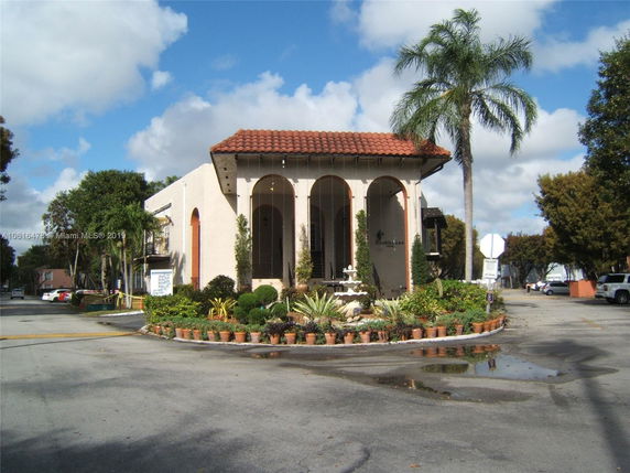 Front view of a building with arches and a red-tiled roof.