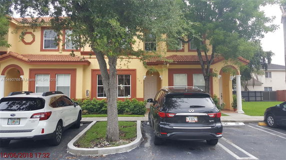 Front view of a two-story house with a parking area in front.