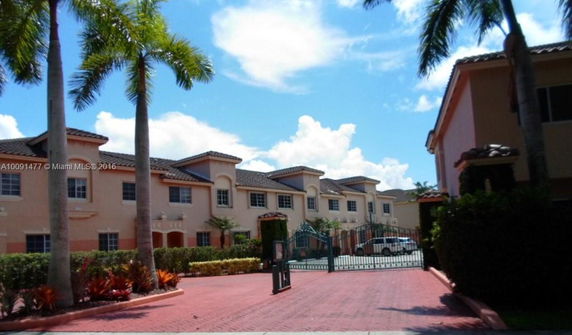 Front view of a gated residential complex with multiple two-story buildings.