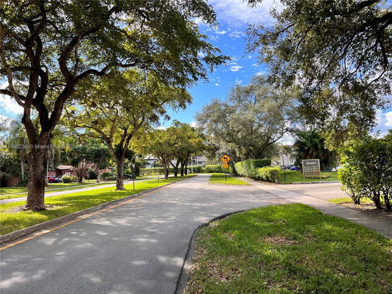 Street view with trees and residential buildings in the background.