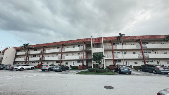Front view of a three-story residential building with a red-tiled roof.