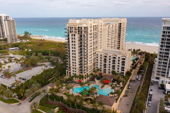 High-rise building with swimming pool and beach in the background.