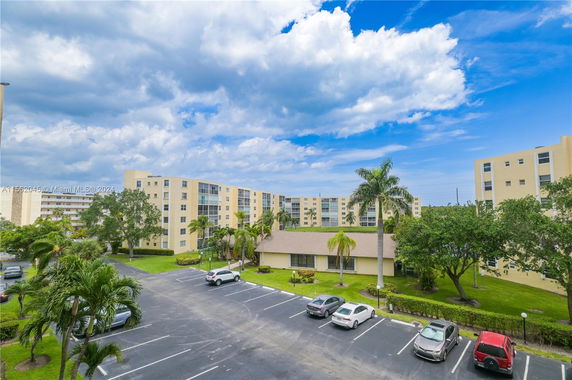 View of multiple residential buildings and a parking area.