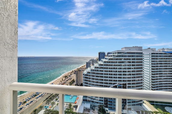Panoramic view from a high vantage point overlooking the ocean and coastal buildings.