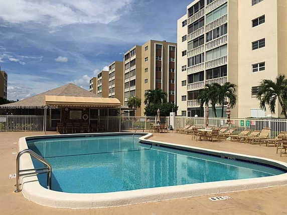 Outdoor swimming pool area with surrounding residential buildings.