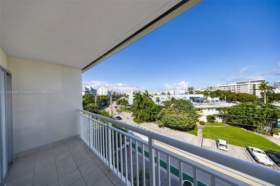 Balcony view overlooking a street and surrounding buildings.