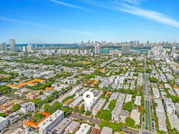 Panoramic aerial view of a city with numerous buildings and a river or bay in the background.