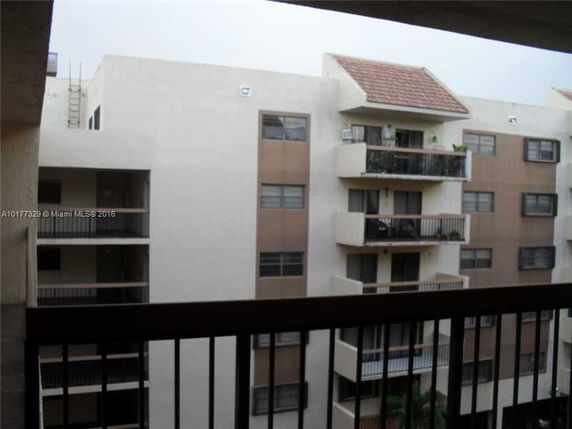 View of a multi-story residential building with several balconies and windows.