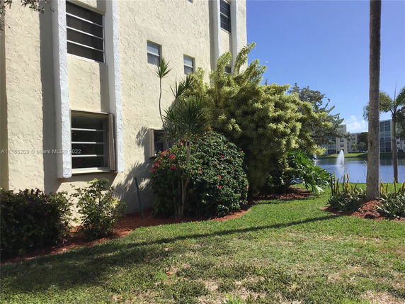 Building exterior with nearby pond and fountain.