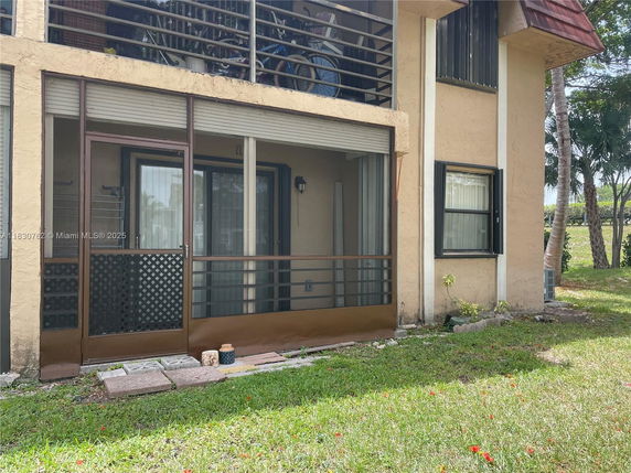 Front view of a two-story residential building with balconies and large windows.