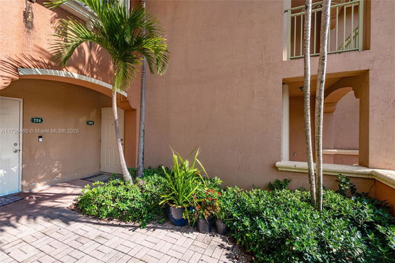 Front view of a building with two entrances labeled 724 and 704, surrounded by plants.