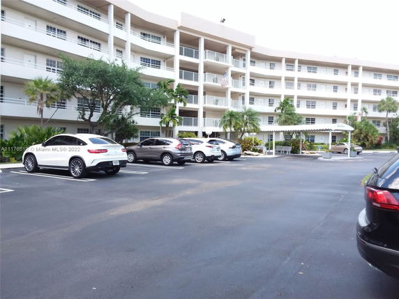 Outdoor parking area in front of a multi-story residential building.