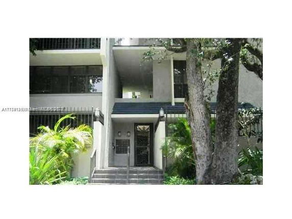 Front view of a multi-story building with balconies and an entrance.