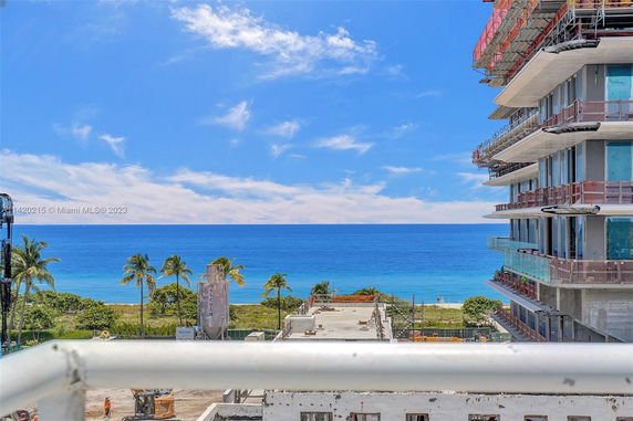Wide view of the ocean and a nearby building under construction.