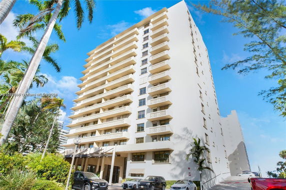 Front view of a high-rise residential building with multiple balconies.