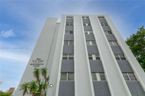 Front view of a multi-story building with white and gray facade.