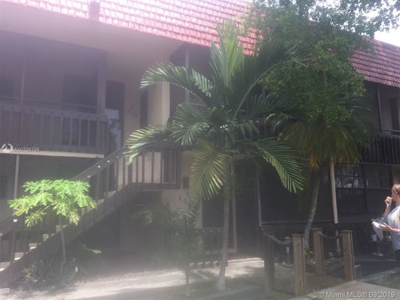 Front view of a two-story residential building with outdoor staircase.