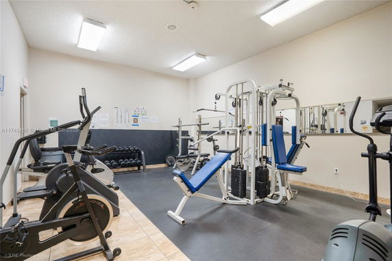 Indoor fitness area with exercise machines and equipment.