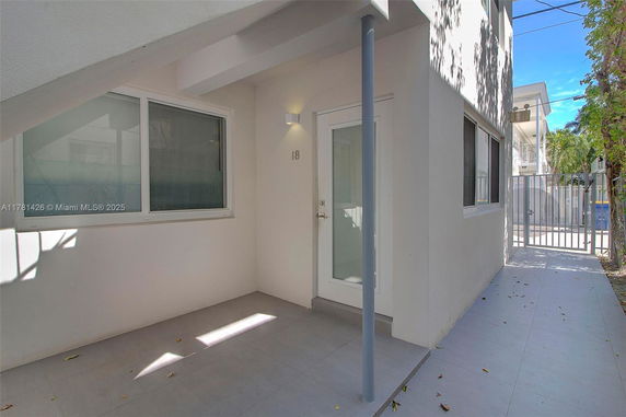 Front view of a building with a glass door, windows, and a covered entrance area.
