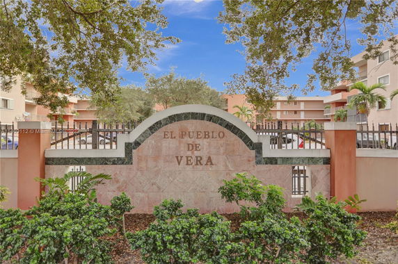 Front view of a multi-story residential building with a decorative entrance sign.