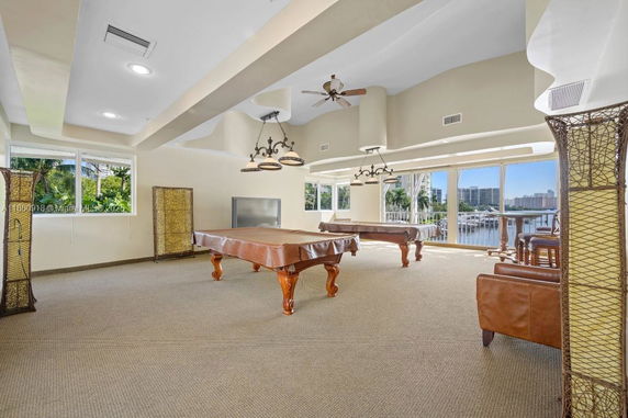 Recreation room with billiards tables and large windows.