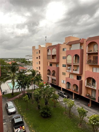 View of a multi-story building with balconies and surrounding area.