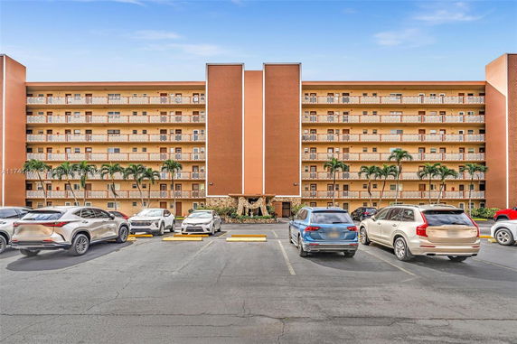 Front view of a multi-story apartment building with balconies.