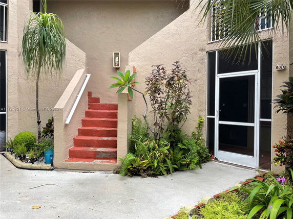 Entrance view with stairs leading to a second-story entrance in a residential building.